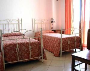 a bedroom with two beds with red comforters at Notti Salentine in Corsano