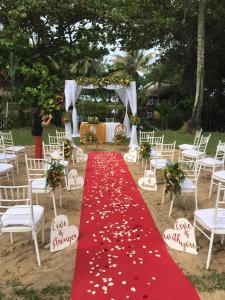 a red wedding aisle with white chairs and a red carpet at Hotel le Lagon in Foulpointe