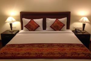 a bedroom with a bed with two lamps and a phone at La Residence in Gurgaon +17 photos