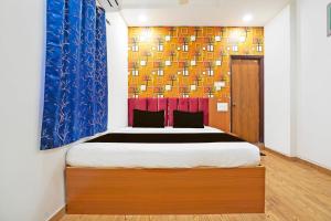 um quarto com uma cama e um quadro na parede em OYO Hotel Sunshine Villa em Nagpur