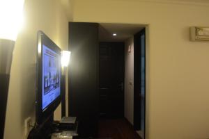 a room with a television and a hallway with a door at La Residence in Gurgaon