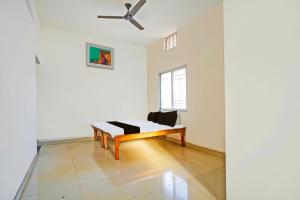 a white room with a bench and a ceiling fan at SPOT ON Hotel SB Air Port Stay in Phundardih