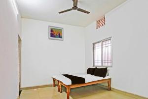 Jest to biały pokój z łóżkiem i wentylatorem sufitowym. w obiekcie SPOT ON Hotel SB Air Port Stay w mieście Phundardih