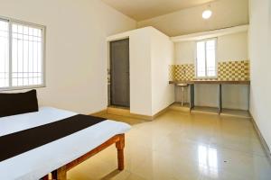 Großes Zimmer mit einem Bett und zwei Fenstern in der Unterkunft SPOT ON Hotel SB Air Port Stay in Phundardih