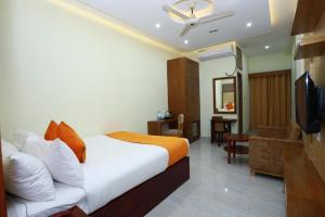 ein Hotelzimmer mit einem Bett und einem TV in der Unterkunft Grand Castle Hotel & Resturant in Comilla