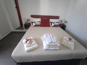 a bedroom with a bed with towels and slippers at Le Suite di Magda Relax & Rooms in Polignano a Mare