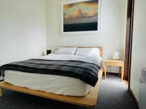 um quarto com uma cama e uma fotografia na parede em Cascade Pad in South Hobart em Hobart