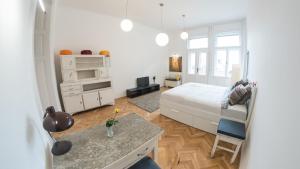 a white bedroom with a bed and a desk in it at NewSunny Apartment at the BudaCastle in Budapest