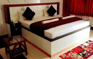 um quarto com uma cama com uma roupa de cama vermelha e branca espectrosspectspectspectspectspectspectspectspectspectspectspectspectspectspects em Vamoose Sachin International em Rudraprayāg