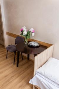 une table avec un vase de fleurs et deux chaises dans l'établissement Laguna, à Loutsk