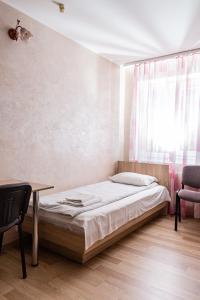 - une chambre avec un lit, un bureau et une fenêtre dans l'établissement Laguna, à Loutsk