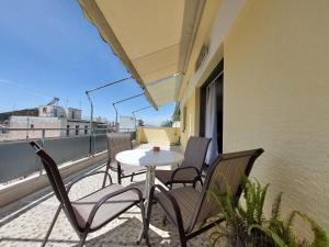 un tavolo e delle sedie sul balcone di un palazzo di Penthouse Anneliese ad Atene