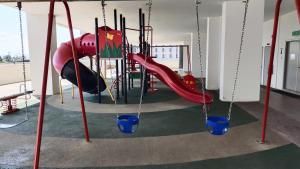 a playground with a red slide and blue buckets at Teratak Seri Indah in Kuala Terengganu