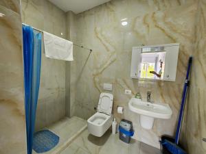 łazienka z toaletą i umywalką w obiekcie Anchor Apartments w mieście Shëngjin