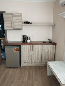 a kitchen with wooden cabinets and a sink and a refrigerator at Oniro PargaTown Luxury Suites in Parga