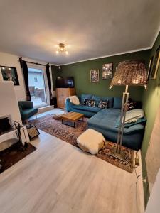 a living room with a blue couch and a lamp at Ferienwohnung "Josefine und Ihr Kavalier" in Kundl