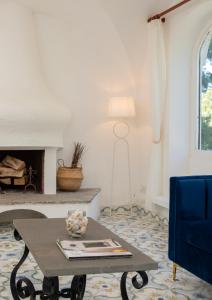 een woonkamer met een tafel en een open haard bij Villa Pineta - Holiday House in Anacapri