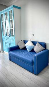 a blue couch in a room with a blue cabinet at Новая квартира с панорамным видом на горы in Almaty