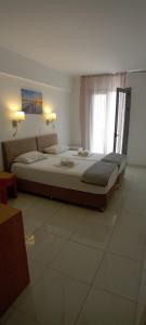 sypialnia z 2 łóżkami i oknem w obiekcie Delfini Hotel w Pireusie