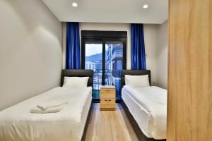 Duas camas num quarto com uma janela em MENE SUITES em Antalya