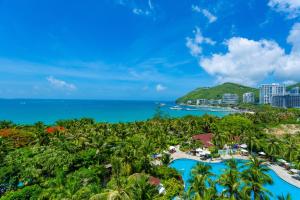 an aerial view of a resort with palm trees and the ocean at Sunshine Resort Intime Sanya in Sanya
