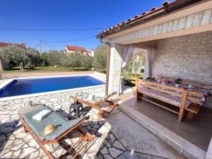 a patio with a table and a picnic table next to a pool at Villa van steen Mirela in Barban