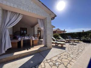 a patio with a table and chairs on a stone patio at Villa van steen Mirela in Barban