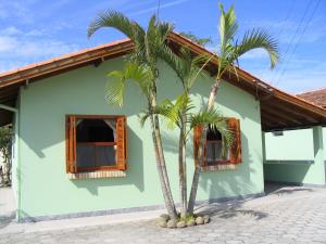 two palm trees in front of a house at Pousada Barratur in Florianópolis