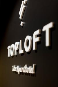 un primer plano del cartel de Topofttenham con el texto de topoforld en Toploft The Aparthotel en Crailsheim