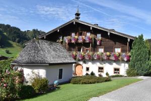 una casa con cajas de flores a un lado. en Brandstatthof Leogang en Leogang