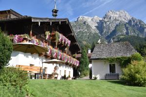 budynek z kwiatami na nim z górami w tle w obiekcie Brandstatthof Leogang w mieście Leogang