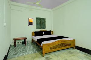 sypialnia z drewnianym łóżkiem w pokoju w obiekcie OYO Flagship Hotel Shiv Residency w mieście Ranchi