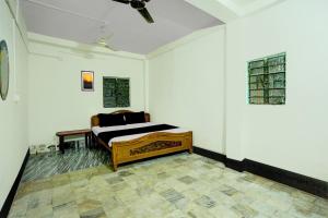 OYO Flagship Hotel Shiv Residency في رانشي: غرفة نوم بسرير في زاوية الغرفة