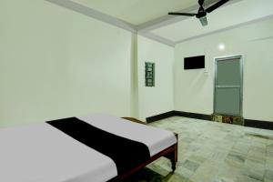 OYO Flagship Hotel Shiv Residency في رانشي: غرفة نوم بسرير ومروحة سقف