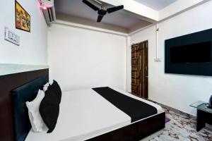 una camera con letto e TV a schermo piatto di OYO Flagship Hotel Savera Inn a Patna