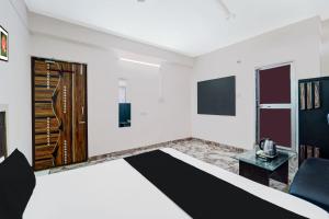 un soggiorno con pareti bianche e una porta in legno di OYO Flagship Hotel Savera Inn a Patna