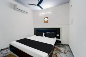 OYO Flagship Hotel Savera Inn في باتنا: غرفة نوم بسرير في غرفة بيضاء