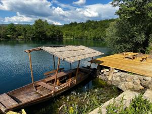 a wooden boat on the water next to a dock at Oasis of peace in Bihać