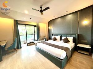 a bedroom with a bed and a ceiling fan at Comfort Inn Silver Arch Hotel, Mussoorie in Mussoorie