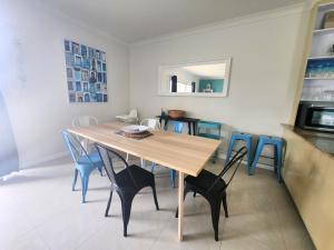 a dining room with a wooden table and blue chairs at Unit 34 Seafront Estate in Jurien Bay