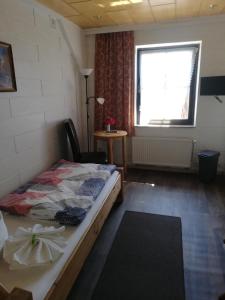 una camera con letto, finestra e tavolo di Pension Haus zum See a Markische Heide