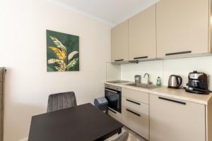 a kitchen with white cabinets and a table and a sink at Studios in Sveta Elena complex with mineral pool in St. St. Constantine and Helena +35 photos