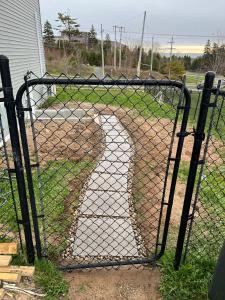 ein Tor mit einem Zaun mit Kettenverbindung vor einer Einfahrt in der Unterkunft Central Halifax one Bedroom apartment in Clayton Park in Halifax