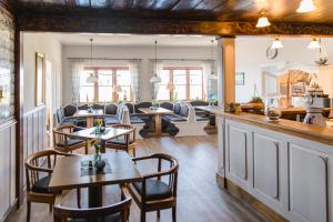 a restaurant with tables and chairs and a living room at Hotel & Gasthaus Hilligenley - auf der Hallig Langeness in Langeneß