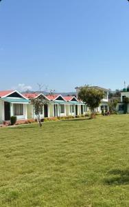 Un grupo de casas en un patio con un campo verde. en Rajaji Retreat, en Rishīkesh
