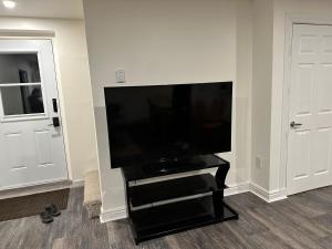 einen Flachbild-TV auf einem schwarzen Stand in einem Zimmer in der Unterkunft Central Halifax one Bedroom apartment in Clayton Park in Halifax