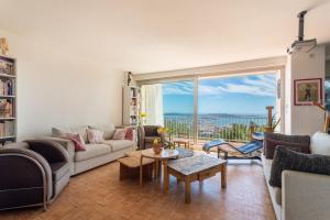 a living room with a couch and a table at 3 bedroom artist's house with AC, spectacular sea view - Dodo et Tartine in Toulon