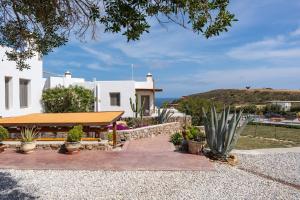a white house with a table and some plants at Luna Rossa Milos - Cocoon in Provatas