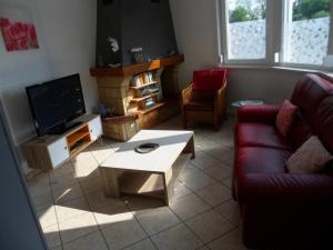 a living room with a couch and a coffee table at Maison individuelle de 100 m2 in Aulnoye-Aymeries