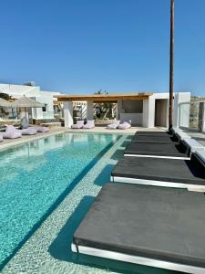 a swimming pool with chaise lounges in a resort at Crystal Suites in Mikonos